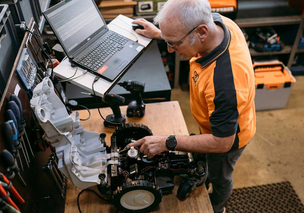 Belousow Mitarbeiter bei Reparatur einer Reinigungsmaschine